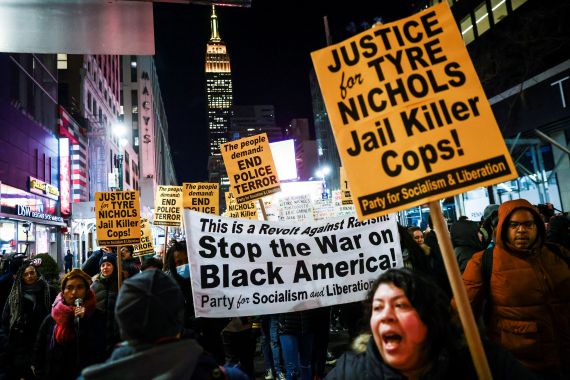 People carry a banner and signs during a protest on the day of the release of a video showing the Memphis police beating of Tyre Nichols, the young Black man who died while hospitalized three days after he was pulled over while driving by Memphis police officers, at a protest in New York, U.S., January 27, 2023. REUTERS/Andrew Kelly