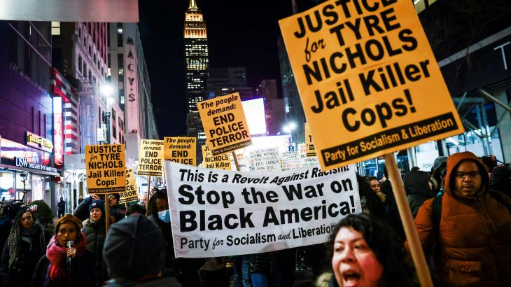 People carry a banner and signs during a protest on the day of the release of a video showing the Memphis police beating of Tyre Nichols, the young Black man who died while hospitalized three days after he was pulled over while driving by Memphis police officers, at a protest in New York, U.S., January 27, 2023. REUTERS/Andrew Kelly