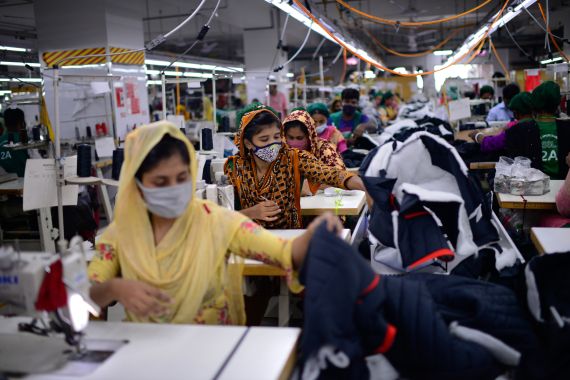 Garment employees work in a sewing section of the Snowtex Outerwear Ltd. factory in Savar, Bangladesh, on Aug. 9, 2021. Bangladesh is suffering through its deadliest surge of the pandemic, but you wouldn't know it looking at its factories, markets and malls. At the Snowtex Outerwear Ltd. factory on the outskirts of Dhaka, the company's 15,000 workers now walk through a “disinfectant tunnel” in which they are sprayed with sanitizer before they get to work turning heaps of fabric into clothing sold in countries around the world. (AP Photo/Mahmud Hossain Opu)