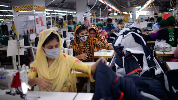 Garment employees work in a sewing section of the Snowtex Outerwear Ltd. factory in Savar, Bangladesh, on Aug. 9, 2021. Bangladesh is suffering through its deadliest surge of the pandemic, but you wouldn't know it looking at its factories, markets and malls. At the Snowtex Outerwear Ltd. factory on the outskirts of Dhaka, the company's 15,000 workers now walk through a “disinfectant tunnel” in which they are sprayed with sanitizer before they get to work turning heaps of fabric into clothing sold in countries around the world. (AP Photo/Mahmud Hossain Opu)