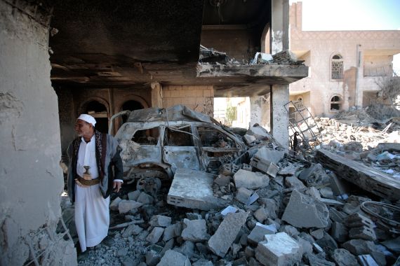 A man inspects the wreckage of a building in Sanaa
