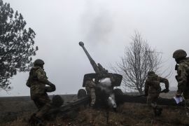 A Ukrainian serviceman fires towards Russian positions
