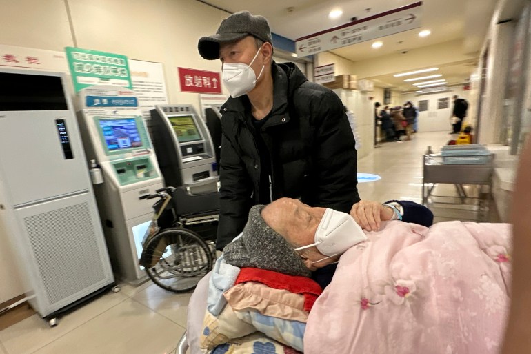 An elderly patient is pushed along a corridor of the emergency ward at a hospital in Beijing, Saturday, Dec. 31, 2022. China is on a bumpy road back to normal life as schools, shopping malls and restaurants fill up again with the easing of COVID-19 restriction. The abrupt end to testing and other measures came as hospitals were swamped with feverish, wheezing COVID-19 patients