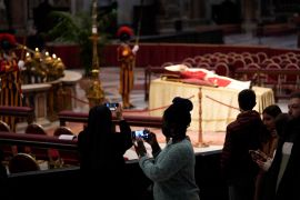 People look at the body of late Pope Emeritus Benedict XVI laid out in state inside St. Peter's Basilica at The Vatican