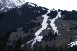 A view of the course, at left, of an alpine ski, men's World Cup giant slalom competition, in Adelboden, Switzerland, Friday, Jan. 6, 2023, the day before the race. Sparse snowfall and unseasonably warm weather in much of Europe is allowing green grass to blanket many mountaintops across the region where snow might normally be. It has caused headaches for ski slope operators and aficionados of Alpine white this time of year.(AP Photo/Gabriele Facciotti)