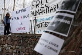 A protester hangs a banner outside a court in Mytilene, on the northeastern Aegean island of Lesbos