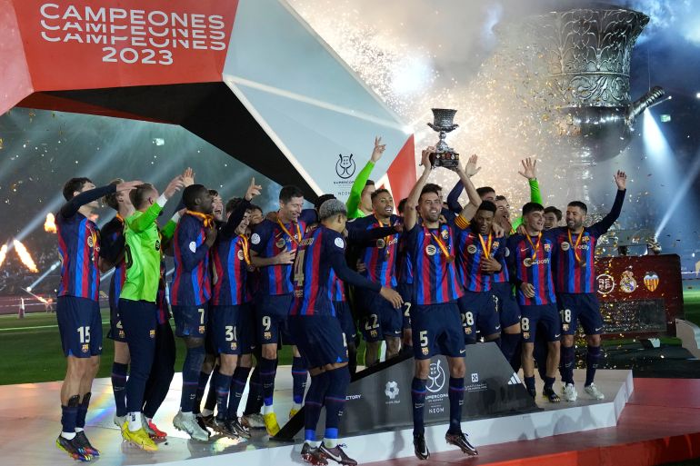 Barcelona players celebrate with a trophy after they won the final of the Spanish Super Cup