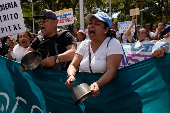Teachers, other public workers and pensioners bang pots as they march for higher salaries and pensions, and payment of their full benefits in Caracas, Venezuela.