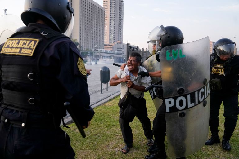 Police detain an anti-government protester in Lima, Peru