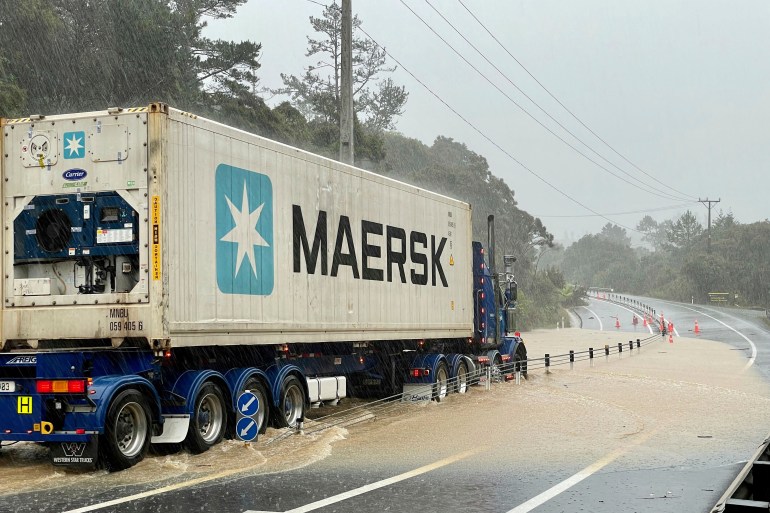 A truck is stopped by flood water near Auckland, New Zealand, Friday, Jan. 27, 2023. Torrential rain and wild weather in Auckland causes disruptions throughout the city and an Elton John concert to be canceled just before it was due to start.