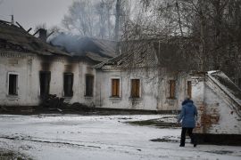 A resident walks past the bombed-out smouldering ruins of a school that was damaged by Russian shelling in the town of Orikhiv in the Zaporizhia region, Ukraine.