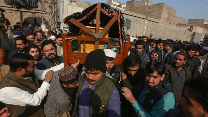 People carry the casket during a funeral for a police officer killed in Monday's suicide bombing inside a mosque, in Peshawar