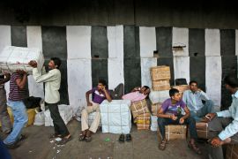 Indian workers rest near goods before transporting them in New Delhi, India