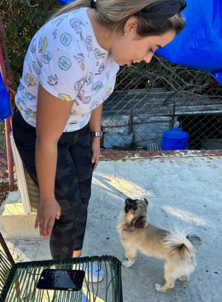 Patri leans over to greet her small dog