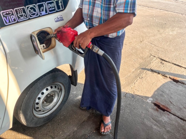 A photo of Lu Zaw filling a car with petrol.