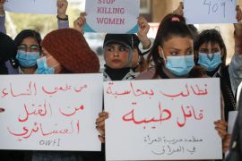 Iraqi women's rights activists lift placards