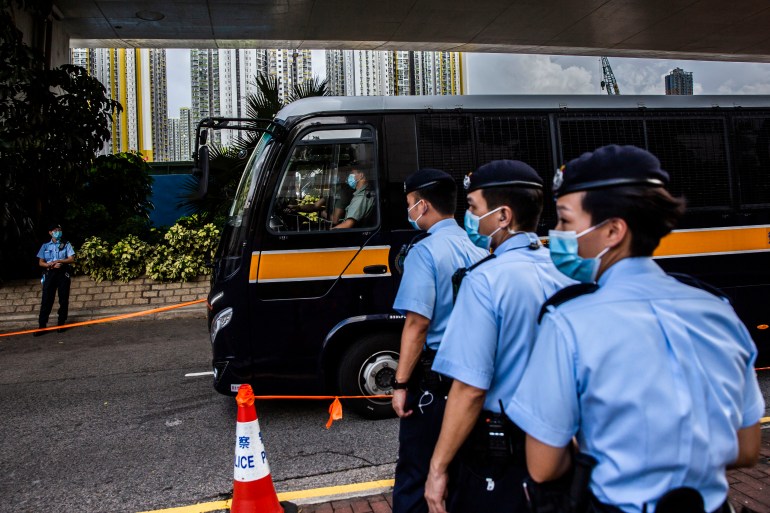 A line of police on the street as a prison van arrives for a pre-trial hearing in relation to the case of the 47