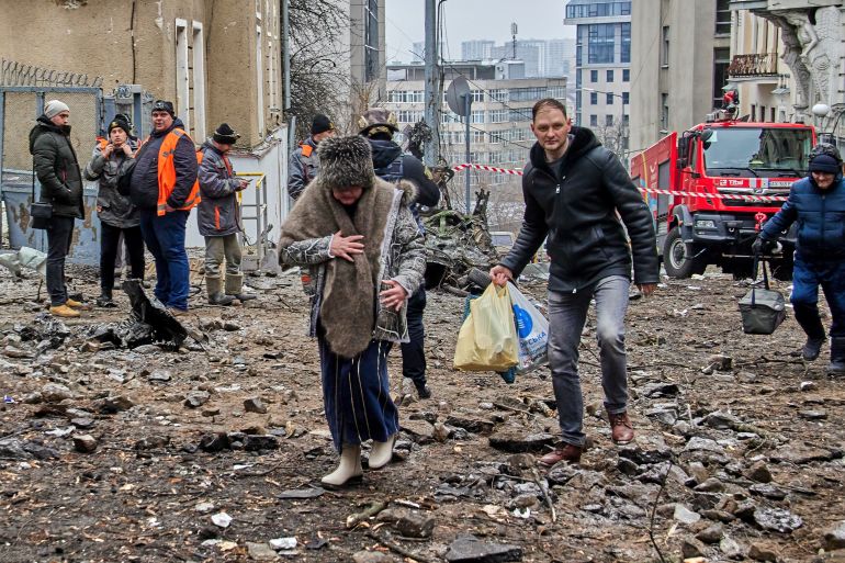 People walking over rubble after a missile attack on Kharkiv