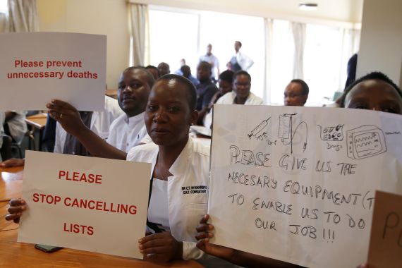 Senior doctors at Parirenyatwa General Hospital, Zimbabwe's biggest medical centre, hold placards during a demonstration to protest a lack of medicines, gloves and bandages in Harare, Zimbabwe March 13, 2019. REUTERS/Philimon Bulawayo