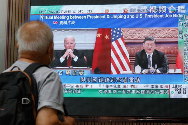 A monitor shows Biden and Xi in a virtual meeting on screen