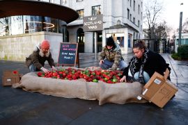 Members of the domestic violence charity 'Refuge' dump plastic rotten apples outside New Scotland Yard during a protest in London, Britain, January 20, 2023. REUTERS/Peter Nicholls