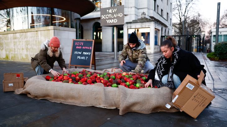 Members of the domestic violence charity 'Refuge' dump plastic rotten apples outside New Scotland Yard during a protest in London, Britain, January 20, 2023. REUTERS/Peter Nicholls