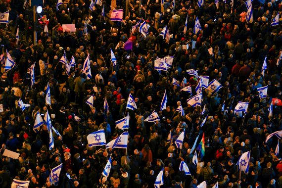 Israelis hold flags as they protest against Prime Minister Benjamin Netanyahu's new right-wing coalition and its proposed judicial reforms.