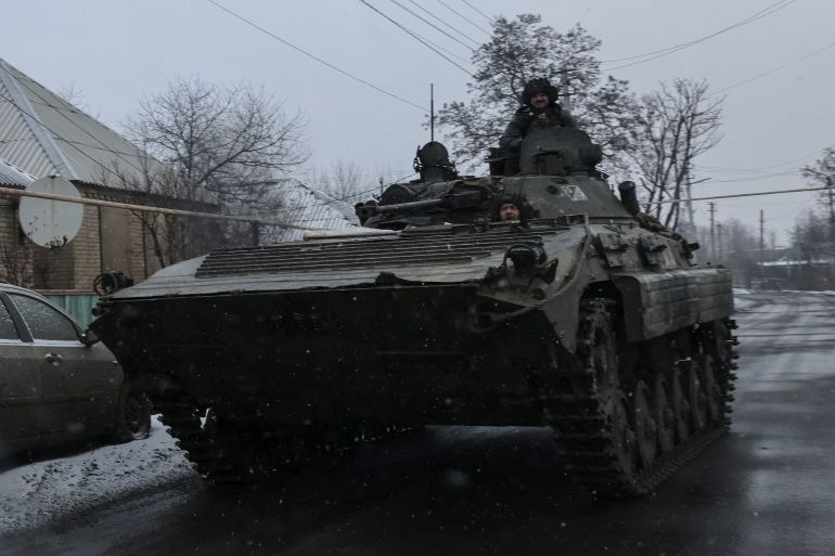 Ukrainian service members ride a BMP-2 infantry fighting vehicle in Donetsk region.