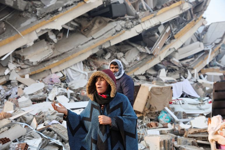 A woman reacts while standing amid rubble, following an earthquake in Hatay, Turkey, February 7, 2023. REUTERS/Umit Bektas