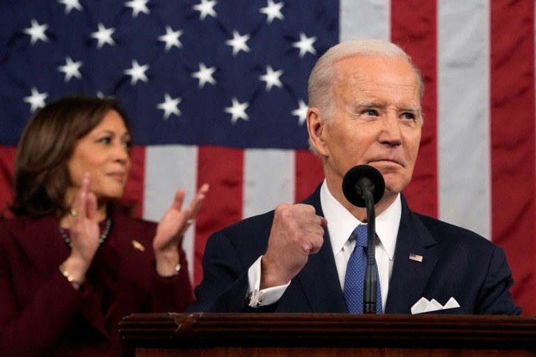 Joe Biden lifts a fist as Kamala Harris applauds
