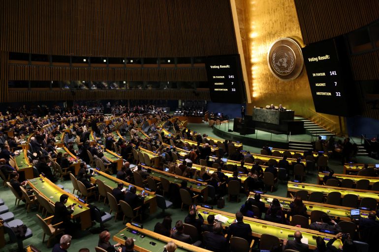 The UN General Assembly chamber with screens showing 141 in favour of the resolution, 7 against and 32 abstentions.