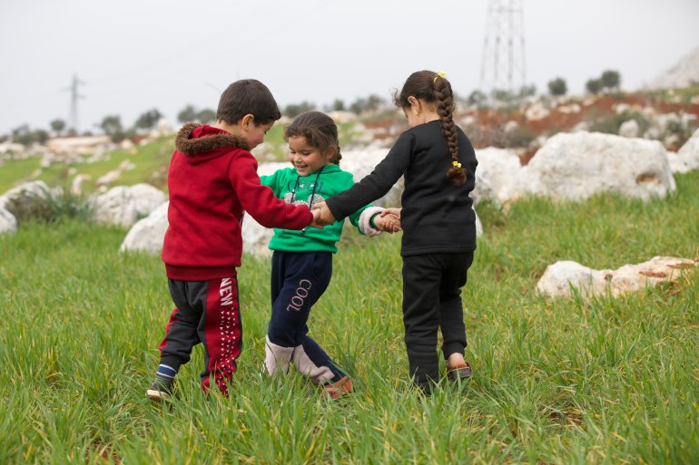 Zuheir, Ilaf and Maryam al-Sayed play in a field