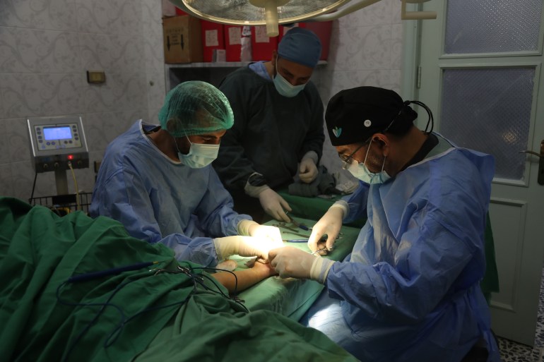 Mohammad Murshed Delimi, a plastic surgeon with the Qatar Red Crescent delegation, operates on a patient's hand in Aqrabat Hospital in northwest Syria 