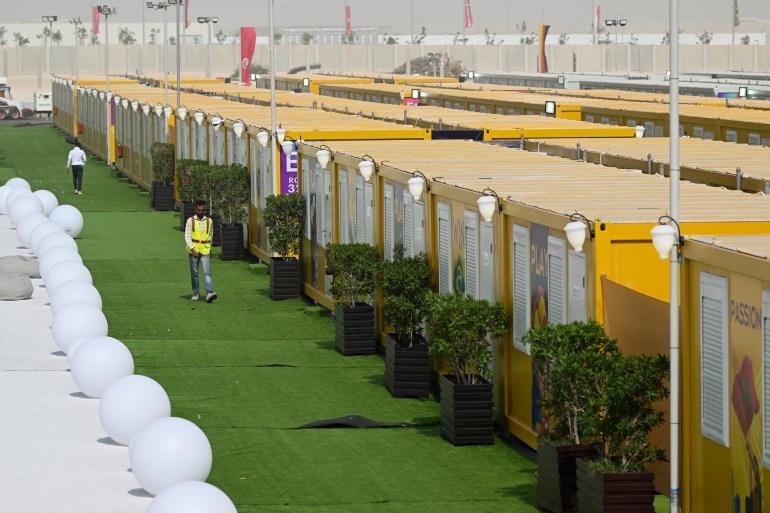 Employees walk past cabins at the Al-Emadi fan village in Doha ahead of the Qatar 2022 FIFA World Cup football tournament.