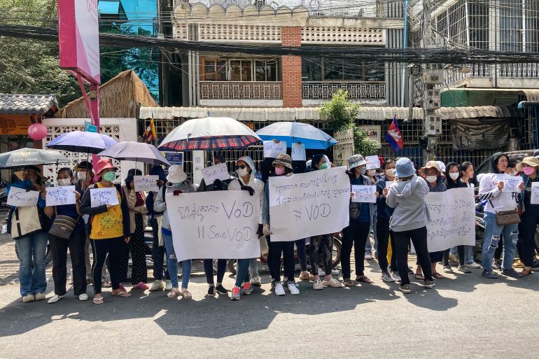 Supporters of VOD gather in Phnom Penh to protest against its closure. They are standing under umbrellas on the street and carrying placards