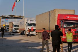 Trucks part of an aid convoy cross from Turkey into rebel-held north Syria through the Bab al-Salama crossing