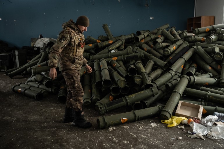 A Ukrainian serviceman of the 93rd brigade stands near a pile of empty mortar shell containers in Bakhmut on February 15, 2023, amid the Russian invasion of Ukraine.