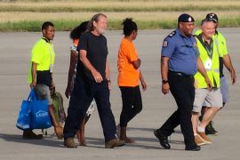 Bryce Barker, who was held for a week in the Papua New Guinea Highlands by an armed group, is escorted from a plane following his release in Port Moresby, Papua New Guinea.