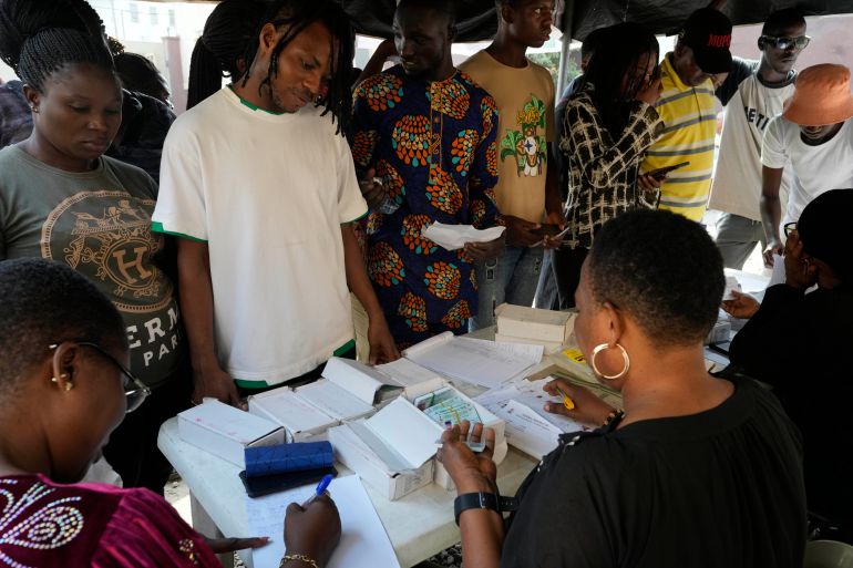 People wait to collect their elections permanent voters card ahead of Feb. 2023 Presidential elections in Lagos, Nigeria, Wednesday, Jan. 11, 2023. (AP Photo/Sunday Alamba)