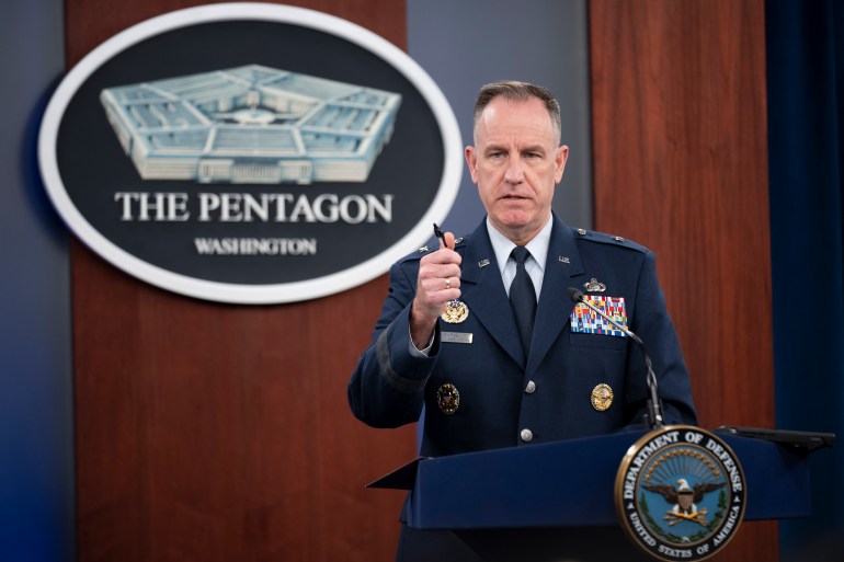 Patrick Ryder at a Pentagon press conference, gesturing from the podium