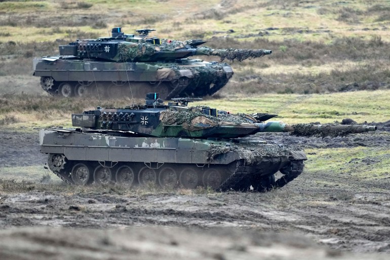 Two Leopard 2 tanks are seen in action during a visit of German Defense Minister Boris Pistorius at the Bundeswehr tank battalion 203 at the Field Marshal Rommel Barracks in Augustdorf, Germany, Wednesday, Feb. 1, 2023. After the government's decision to deliver fourteen Leopard 2 tanks to Ukraine, the capabilities of the Leopard 2A6 main battle tank are shown at a presentation in Augustdorf. (AP Photo/Martin Meissner)