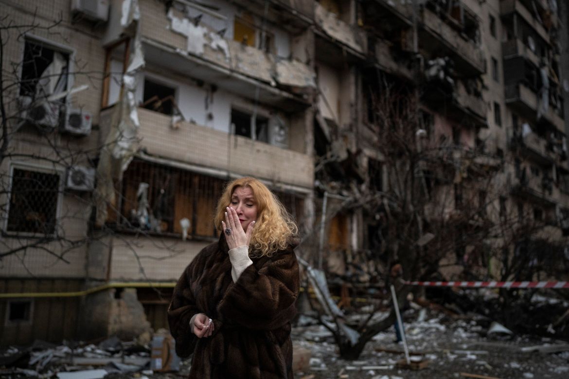 Natali Sevriukova is overcome with emotion as she stands outside her destroyed apartment building following a rocket attack in Kyiv