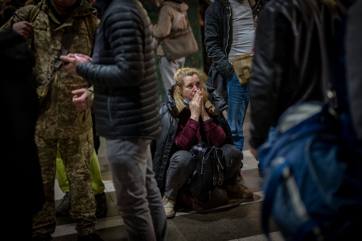 A woman reacts as she waits for a train trying to leave Kyiv