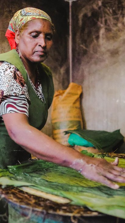 Menteha Hussain's skilled hands flatten the dough and layer it in 'koba', false banana leaves, to cook
