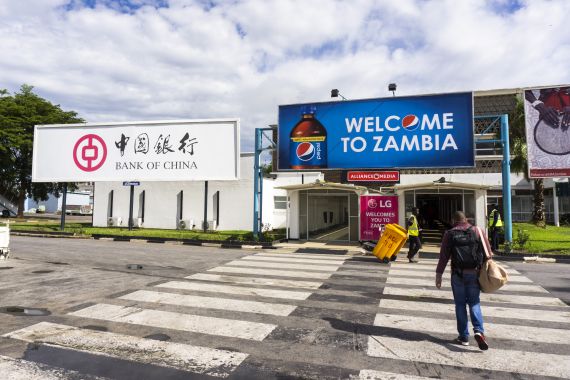 A Bank of China billboard, left, and a PepsiCo Inc. adveritsement stand outside the arrivals area at Kenneth Kaunda International Airport in Lusaka, Zambia, on Tuesday, Dec. 11, 2018. Most of the digital infrastructure projects in Zambia, like the more visible airport terminals and highways, are being built and financed by China, putting the country at what the International Monetary Fund calls a high risk of debt distress. Photographer: Waldo Swiegers/Bloomberg via Getty Images