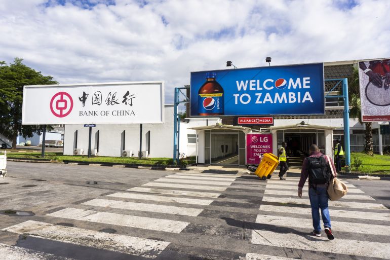 A Bank of China billboard, left, and a PepsiCo Inc. adveritsement stand outside the arrivals area at Kenneth Kaunda International Airport in Lusaka, Zambia, on Tuesday, Dec. 11, 2018. Most of the digital infrastructure projects in Zambia, like the more visible airport terminals and highways, are being built and financed by China, putting the country at what the International Monetary Fund calls a high risk of debt distress. Photographer: Waldo Swiegers/Bloomberg via Getty Images