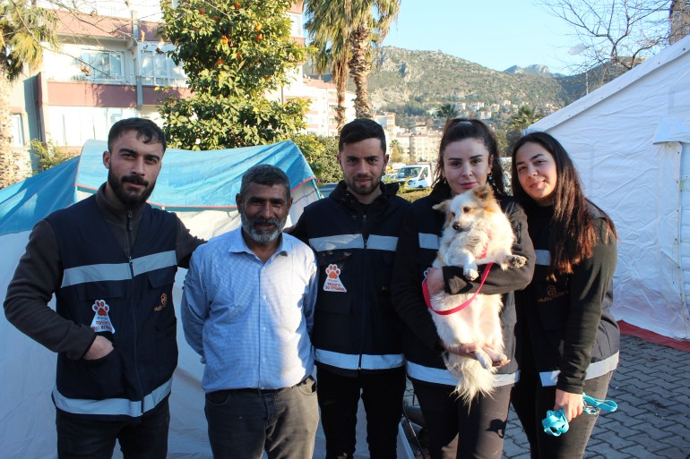 Rabia Öztürk, field coordinator of animal welfare group Mutlu Patiler, holds a dog rescued in Antakya alongside her team