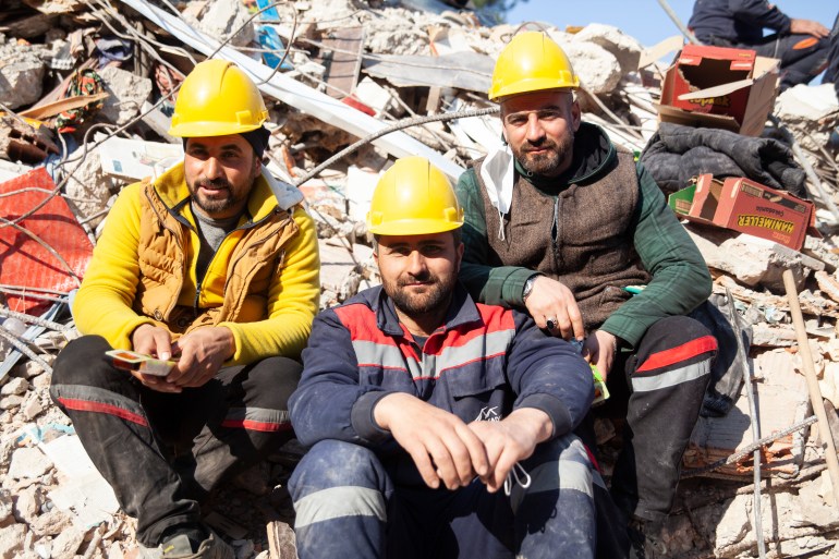 Construction workers wait to be called again in case something goes wrong under the rubble