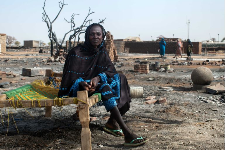 A handout picture released by the United Nations-African Union Mission in Darfur shows a displaced woman posing on a makeshift bed as she came to inspect the remains of her burned house in Khor Abeche, 83km northeast of Nyala. South Darfur.