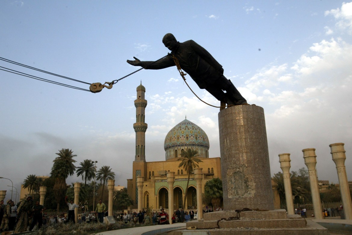 A statue of Iraq's President Saddam Hussein falls as it is pulled down in central Baghdad